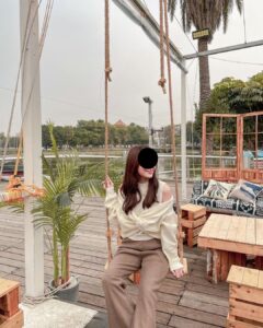 Photo that the WhatsApp scammer used, showing a young woman sitting on a swing