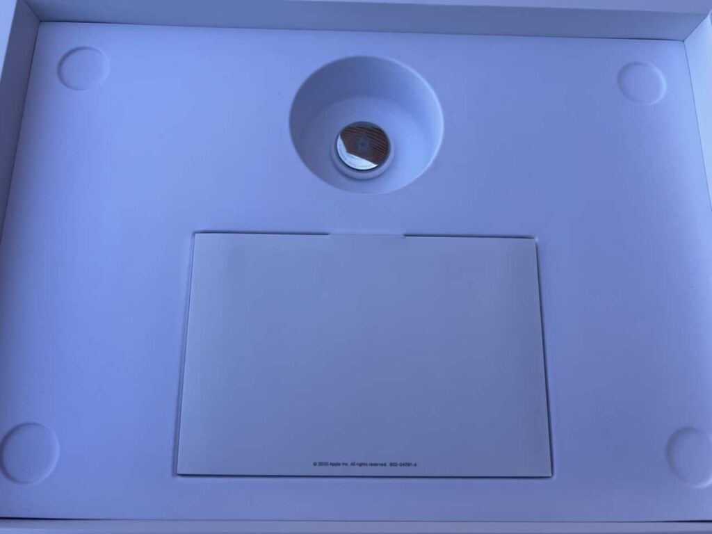 photo of an apple airtag inside an empty macbook pro box