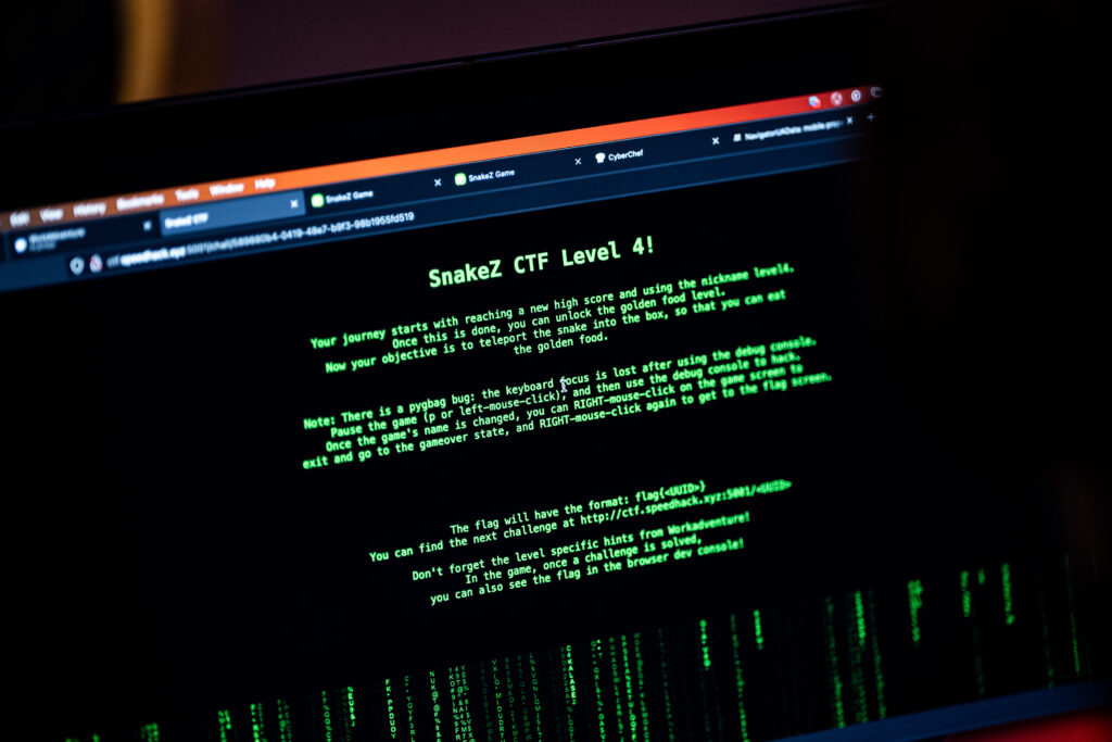 Photo of a laptop with the CTF Level 4  page open. The page has green text on a black background and the Matrix-inspired vertical code background under the text box