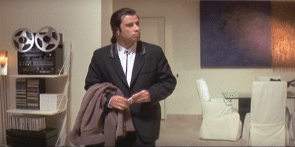 GIF of a confused Vincent Vega, played by John Travolta, looking around a room. From the movie Pulp Fiction.