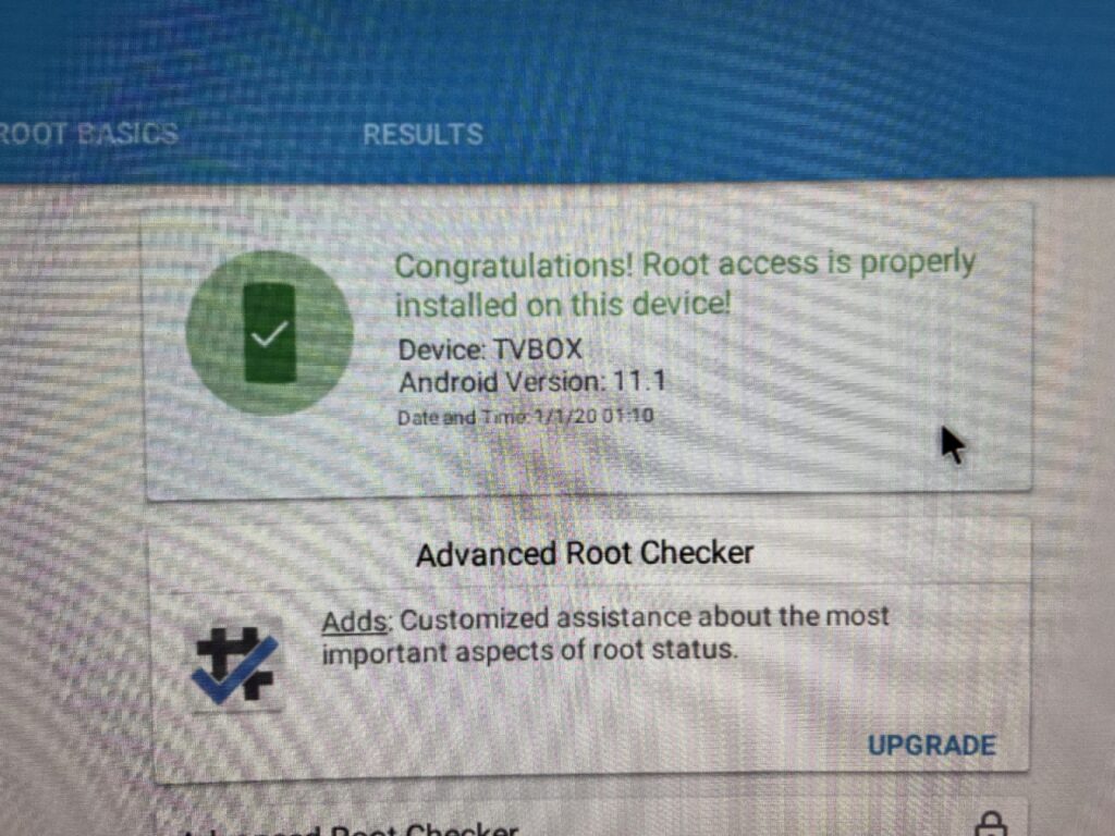 A grainy photo of a device's screen that shows a green check mark with the following text: Congratulations! Root access is properly installed on this device!