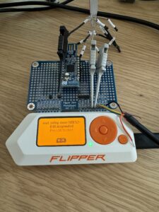 A white electronic device with wires and a yellow screen Description automatically generated
