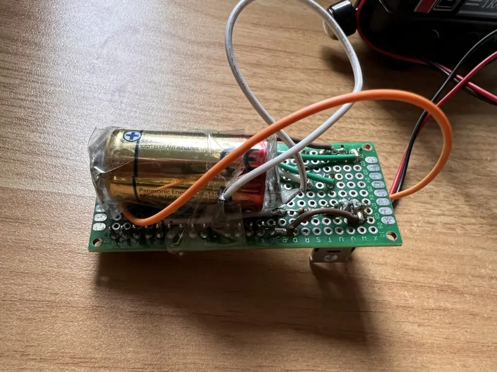 Photo of a pcb with a CR123A 3 V battery soldered to it
